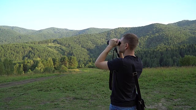 徒步旅行者和游客用双筒望远镜观察自然景观。山视频素材