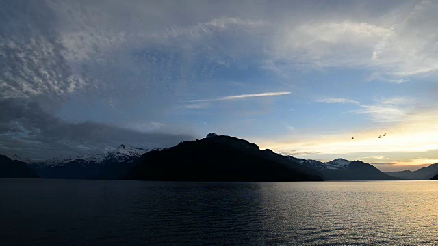 瑞士中部壮丽的山脉和湖泊全景。夕阳把云彩涂上了壮丽的色彩。宽镜头。视频素材