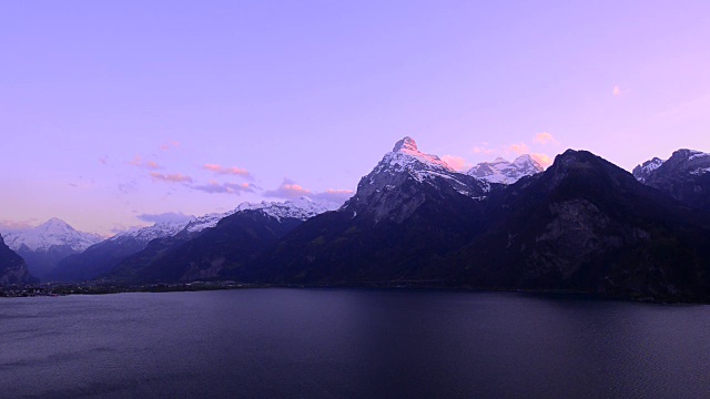 瑞士中部壮丽的山脉和湖泊全景。夕阳把云彩涂上了壮丽的色彩。宽镜头。视频素材