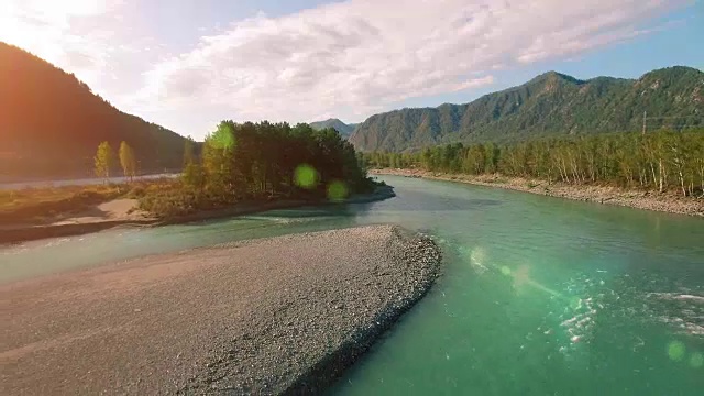 全高清FHD鸟瞰图。在阳光明媚的夏日清晨，低空飞过新鲜寒冷的山间河流。绿树和阳光洒在地平线上视频素材