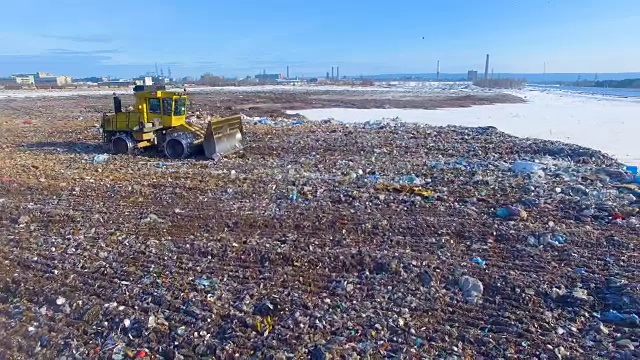 推土机在城市垃圾填埋场工作。无人驾驶飞机,4 k。视频素材