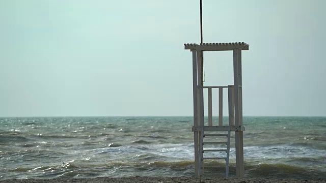 淡季时空旷沙滩上的救生员塔。有风的日子和暴风雨的大海视频素材