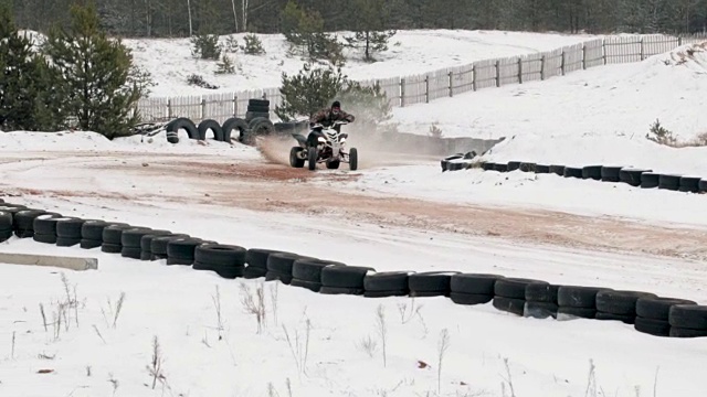 冬天的时候，他开着一辆沙滩车行驶在积雪覆盖的路上视频素材