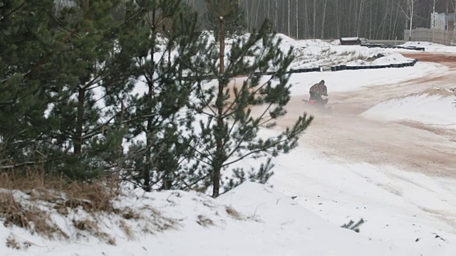 冬天的时候，他开着一辆沙滩车行驶在积雪覆盖的路上视频素材