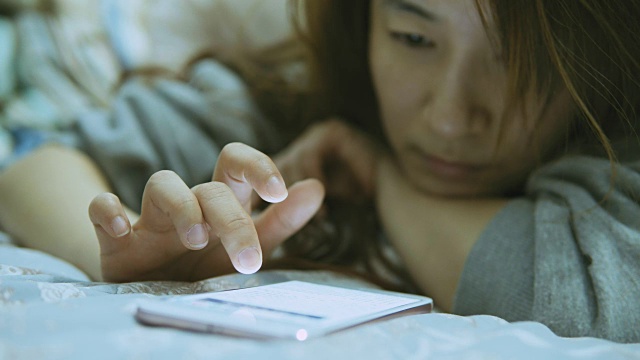 晚上在床上用手机的女人视频素材