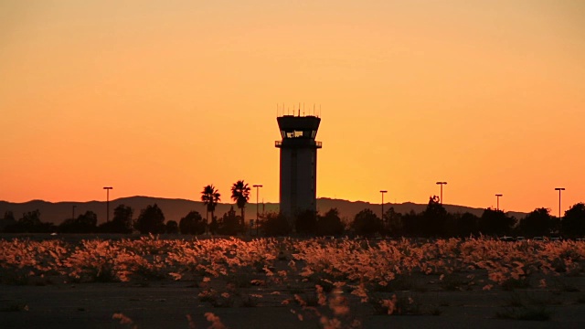 飞机在日落时分由空中交通塔起飞视频素材