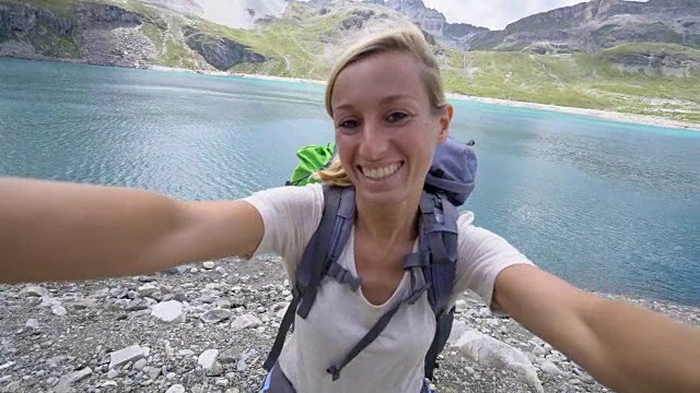 徒步旅行的年轻女子在湖边自拍视频素材