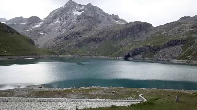 无人机拍摄，一名年轻女子在徒步旅行站在她的帐篷附近美丽的山湖双臂伸展视频素材