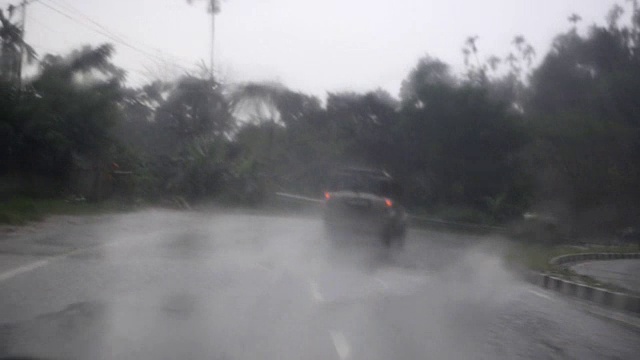 在雨中移动的雨刷和追逐汽车的广泛镜头。视频下载