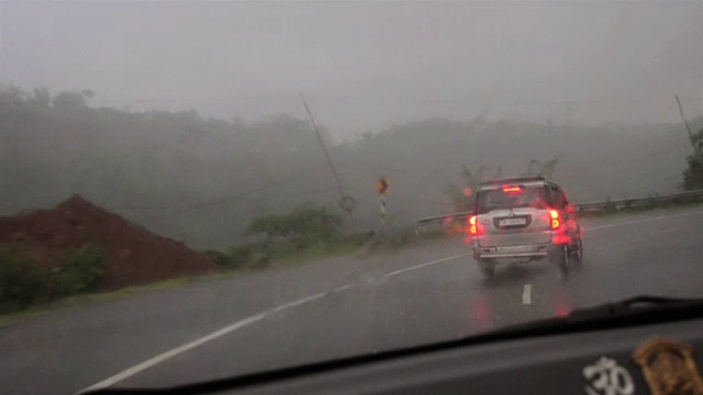 在雨中移动的雨刷和追逐汽车的广泛镜头。视频下载