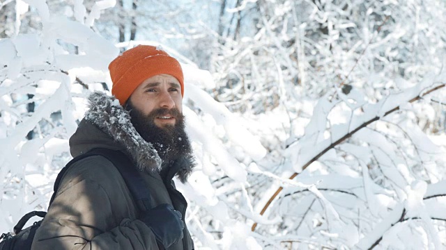 一名男子在一个冬日下雪天的户外对着镜头微笑和挥手视频素材