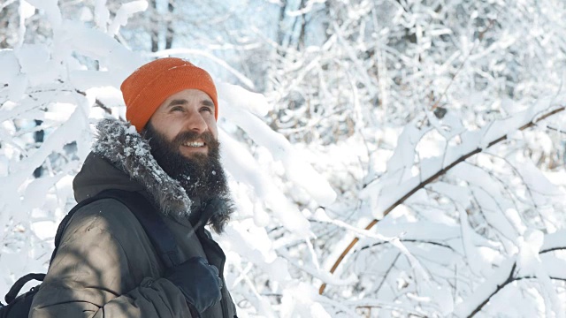 一名男子在一个冬日下雪天的户外对着镜头微笑和挥手视频素材