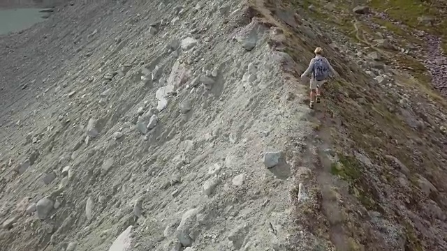 一名年轻女子在瑞士的山脊上徒步旅行的无人机镜头视频素材