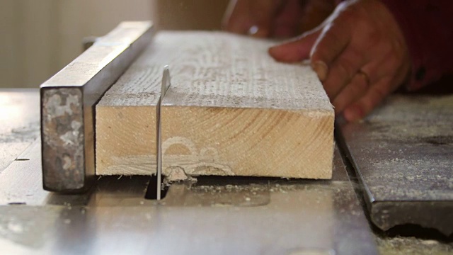 在一家家具厂，工人正在用圆锯切割木板视频素材