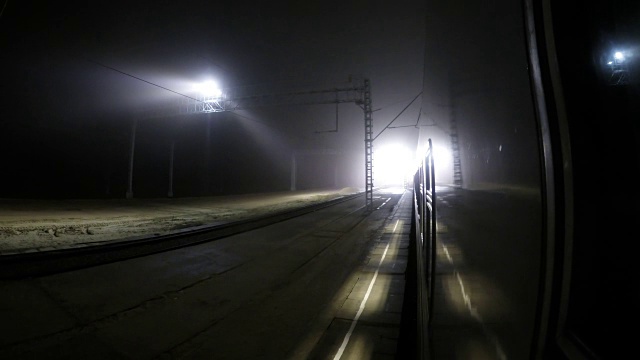 视角夜车疾驶，火车到站和离开站台，时间流逝，夜间灯光反射在火车的窗户视频素材