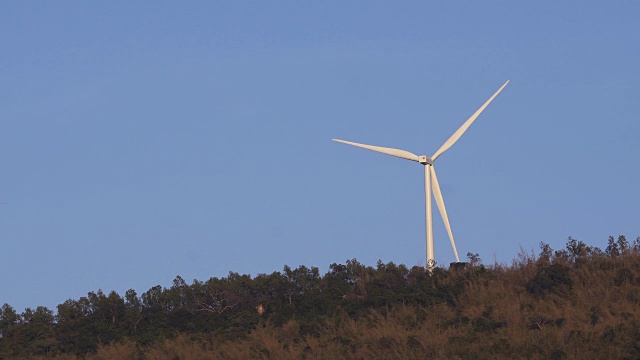 风力涡轮机在农场，山小山的背景。视频素材