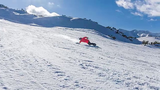 在一个阳光明媚的日子里，滑雪者从滑雪坡上滑下来，将雪喷向摄像机视频素材