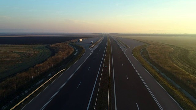 无人机拍摄的高速公路和农田上的日落视频素材