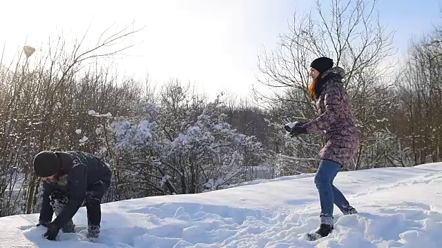 一对夫妇在雪地里打雪仗。视频素材