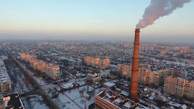 高空拍摄的高热气烟囱与缓慢上升的烟在日落在冬天视频素材