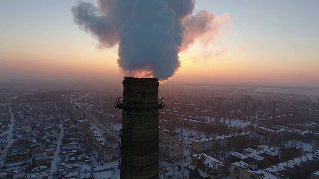 空中特写拍摄的一个巨大的工业塔与白色烟雾在日落在冬天视频素材