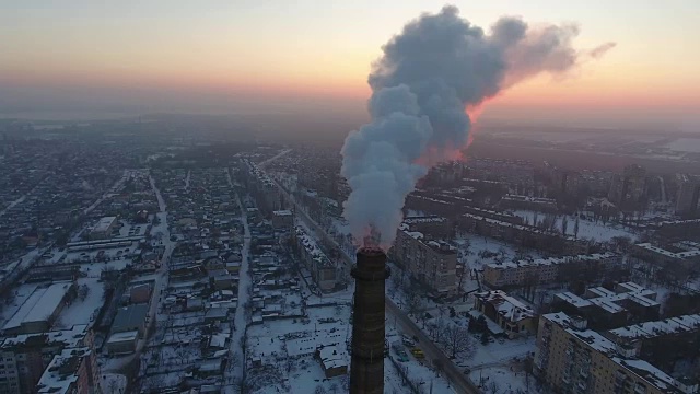 空中拍摄的高工业管道与白色烟雾和城市景观在冬天视频素材