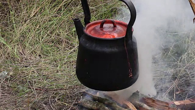 野外露营时在篝火上准备食物视频素材