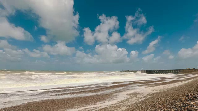 在法国诺曼底的英吉利海峡海滩上，云景观和冲击海浪的时间流逝。晴朗的一天，迪耶普港狂风暴雨，蓝天白云视频素材