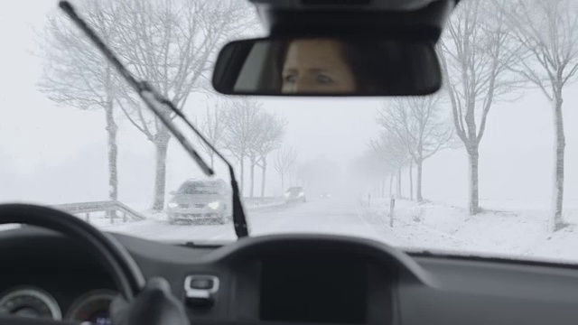 冬季驾驶——大雪下的乡村道路上迎面而来的车辆视频素材