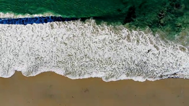 从空中俯瞰俯瞰清澈的海水，汹涌的海浪和位于加州橘郡拉古纳的盐溪沙滩视频素材