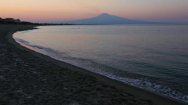 黄昏的Agnone Bagni海滩和遥远的埃特纳火山(锡拉库萨，西西里岛，意大利)视频素材