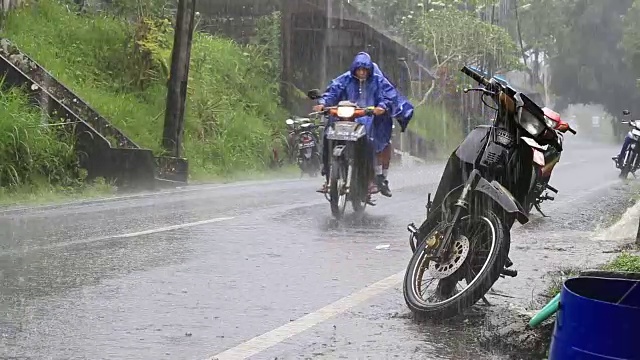 在印度尼西亚的巴厘岛乌布，下雨时，一条典型的街道上的交通视频素材