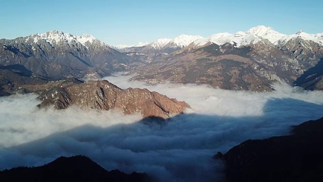 无人机鸟瞰图的奥罗比阿尔卑斯山。山上刚下过雪。雾笼罩着山谷和村庄。意大利贝加莫法诺山的全景图视频素材