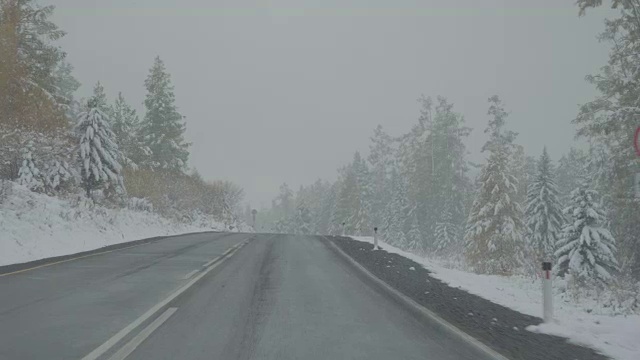 驾驶汽车在冬季的山路上下雪POV视频素材