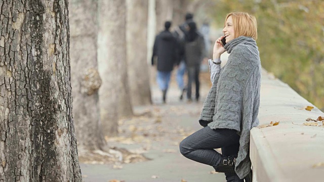 一个年轻的白人妇女正在市中心的街道上打电话视频素材