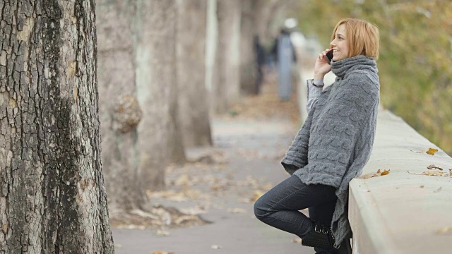 在街上用智能手机的微笑女人:正在打电话的快乐女人视频素材