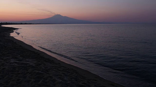 黄昏的Agnone Bagni海滩和遥远的埃特纳火山(锡拉库萨，西西里岛，意大利)视频素材