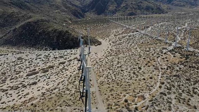 空中扫射的风力涡轮机与沙漠和山脉在棕榈泉，加州的田野视频素材