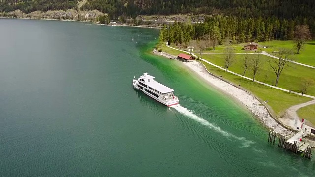 航拍:在奥地利阿尔卑斯山脉的阿钦湖拍摄一艘游船视频素材