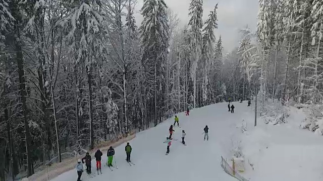 滑雪者和滑雪板爱好者在山上的滑雪坡上滑行。视频素材