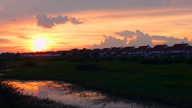 天空日落，绿色草地和池塘作为前景视频素材