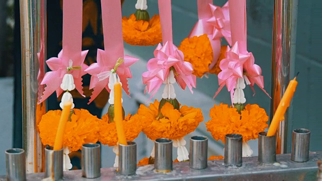 泰国传统佛教祭坛附近的蜡烛和鲜花视频素材