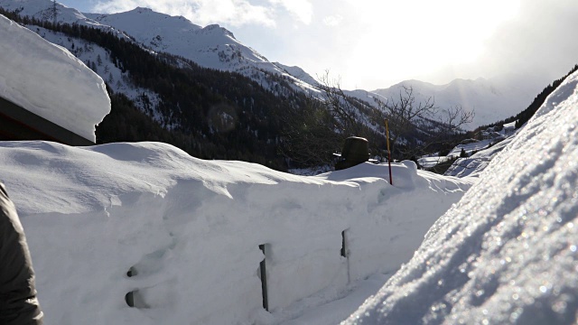 一名男子沿着雪地走廊穿过村庄视频素材