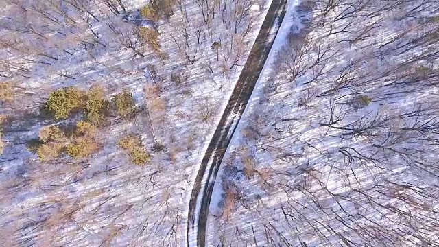 鸟瞰图弯曲的道路在一个被雪覆盖的山边视频下载