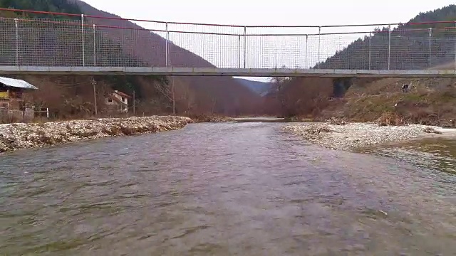 四轴飞行器低低地飞过桥下的河水视频素材