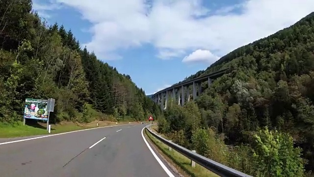 在奥地利，骑摩托车的旅行者在风景优美的山路上骑行视频素材