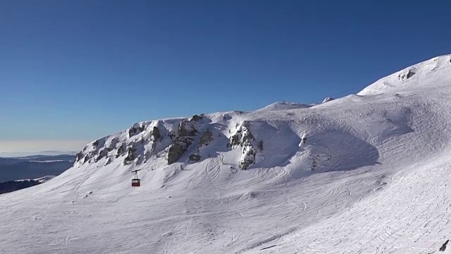 空中的慢动作镜头在蓝天上的雪山山脊山谷。视频素材