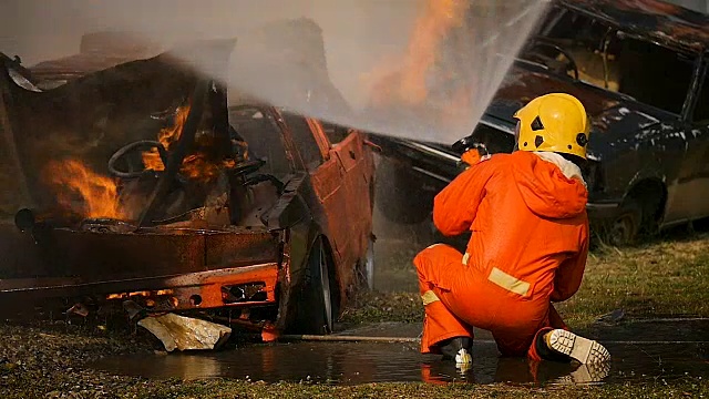 消防队员在灭火行动中，高压水枪将水喷到火焰周围，烟雾弥漫视频素材