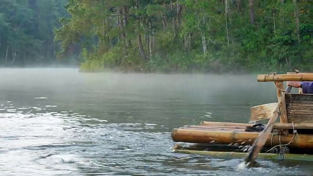 近距离观看木船划桨在竹筏通过雾漂浮在湖面上在早上在庞ung, Mae Hong Son，泰国视频素材