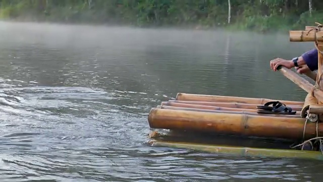 近距离观看木船划桨在竹筏通过雾漂浮在湖面上在早上在庞ung, Mae Hong Son，泰国视频素材